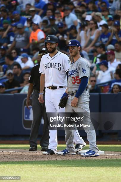 Eric Hosmer of the San Diego Padres and Cody Bellinger of the Los Angeles Dodgers joke around at first base during the game at Estadio de Béisbol...