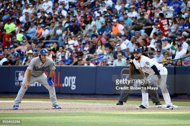 Joc Pederson of the Los Angeles Dodgers leads off first base as Eric Hosmer of the San Diego Padres holds him on during the game at Estadio de...