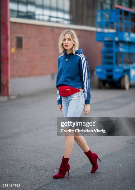 Lisa Hahnbueck wearing cropped Levis 501 denim jeans, blue cropped Adidas hoodie, Gianvito Rossi sock boots, red vintage Chanel velvet fanny belt bag...