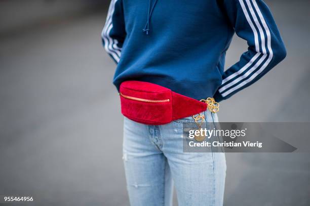 Lisa Hahnbueck wearing cropped Levis 501 denim jeans, blue cropped Adidas hoodie, Gianvito Rossi sock boots, red vintage Chanel velvet fanny belt bag...