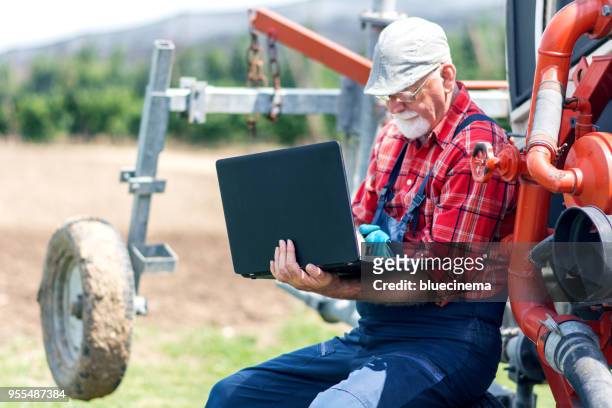 landwirt mit laptop auf dem bauernhof - rural development stock-fotos und bilder