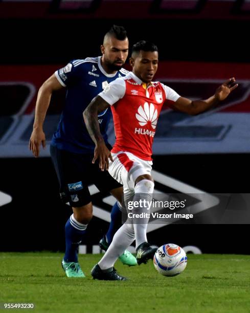 Wilson Morelo of Independiente Santa Fe struggles for the ball with Andres Cadavid of Millonarios during a match between Independiente Santa Fe and...