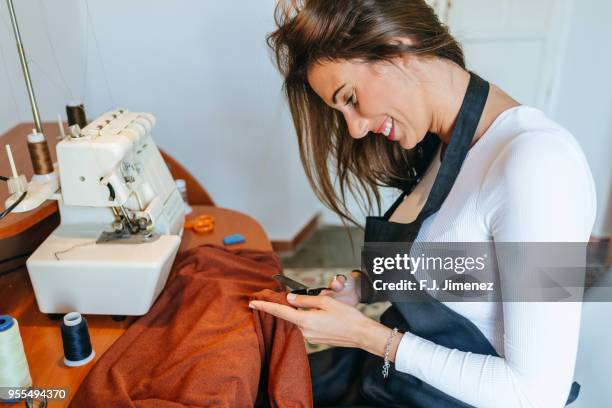 woman seamstress cutting the fabric - costura stock pictures, royalty-free photos & images