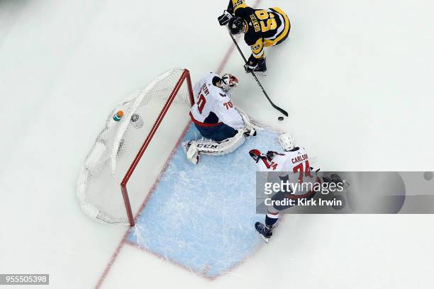 Jake Guentzel of the Pittsburgh Penguins attempts to shoot the puck at Braden Holtby of the Washington Capitals as John Carlson plays defense in Game...