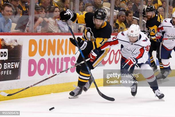 Riley Sheahan of the Pittsburgh Penguins and Evgeny Kuznetsov of the Washington Capitals chase after the puck in Game Four of the Eastern Conference...