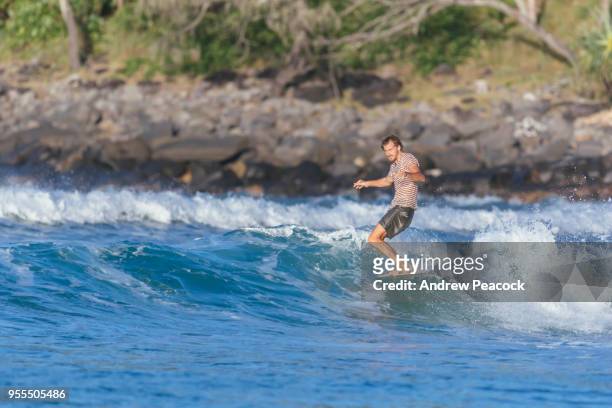 mitchell surman is surfing on the nose of a longboard at tea tree bay, noosa national park - andrew surman photos et images de collection