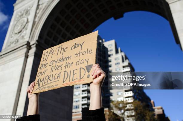 Placard reading "11/9: The day the system stole our lives, the day America died!" is held up at a "Love Rally" in Washington Square Park organised in...