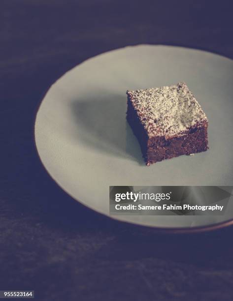 slice of chocolate cake with powdered sugar on plate - samere fahim fotografías e imágenes de stock