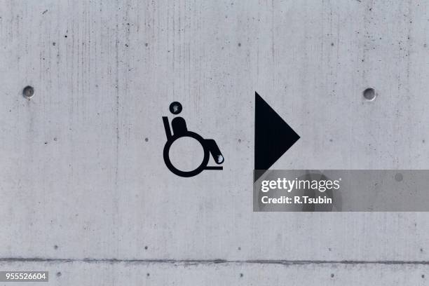 image of an accessibility symbol on a peering stone wall - accessibility stock-fotos und bilder