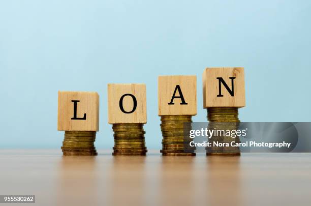 loan text written on wooden block with stacked coins - loan stock pictures, royalty-free photos & images