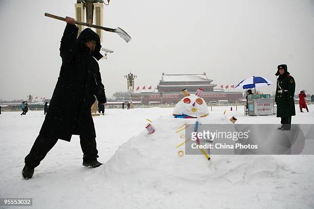 Man makes a snowman in snow at the Tiananmen Square on January 3, 2010 in Beijing, China. The biggest snowfall in nearly 60 years blanketed Beijing...