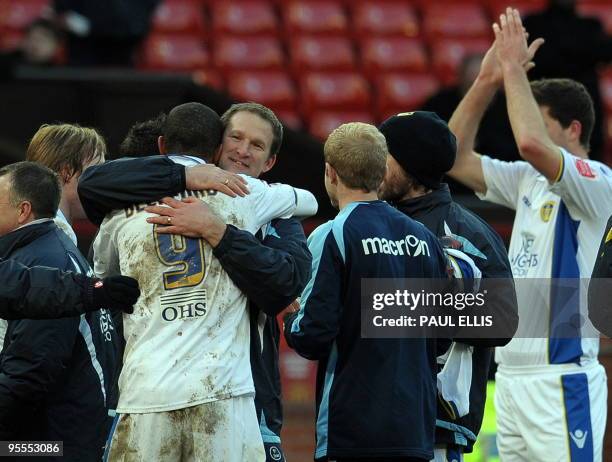 Leeds United manager Simon Grayson congratulates goalscorer, English forward Jermaine Beckford, after beating Manchester United 0-1 in their English...