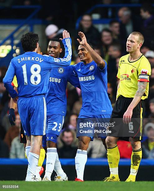 Jay DeMerit of Watford looks dejected as Florent Malouda of Chelsea celebrates with Yuriy Zhirkov and Daniel Sturridge as he scores their third goasl...