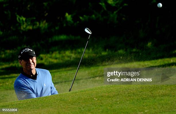 Golfer Tom Watson plays out of a bunker on the 5th hole during the play-offs against US golfer Stewart Cink, on the final day of the 138th British...