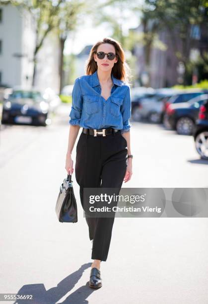 Alexandra Lapp wearing high waist black ankle cropped trousers by Zara, a blue Steffen Schraut denim shirt, a black vintage logo belt by Hermes, the...
