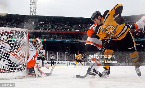 Byron Bitz of the Boston Bruins takes a shot against Michael Leighton of the Philadelphia Flyers during the 2010 Bridgestone Winter Classic at Fenway...