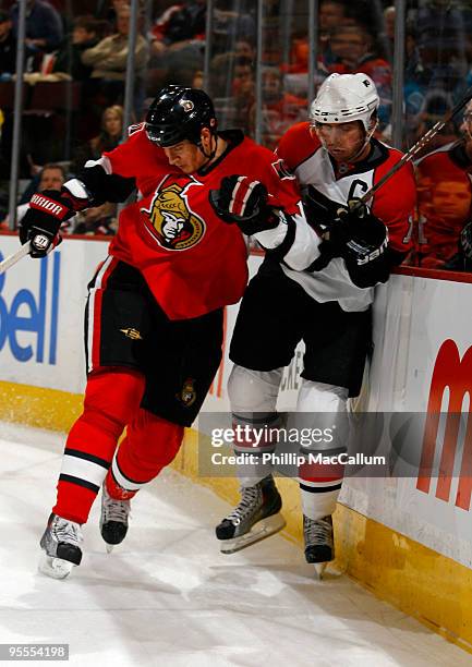 Filip Kuba of the Ottawa Senators throws a bodycheck on Mike Richards of the Philadelphia Flyers in a game at Scotiabank Place on January 3, 2010 in...