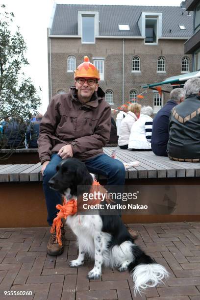 Family A man with his dog sits outside during the celebrating of the Koningsdag or the King's day April 27 in Katwijk, Netherlands. King's day is ta...