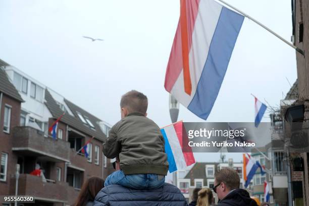 Boy sits on a shoulder of his father during a celebration of the Koningsdag or the King's day April 27 in Katwijk, Netherlands. King's day is a...