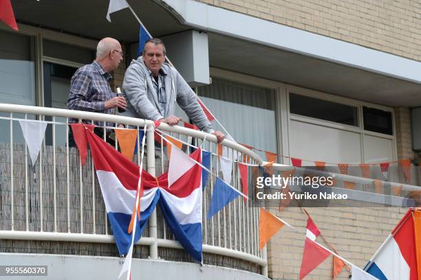 Men have a chat outside a decorated balcony during the Koningsdag or the King's day April 27 in Katwijk, Netherlands. King's day is a national...