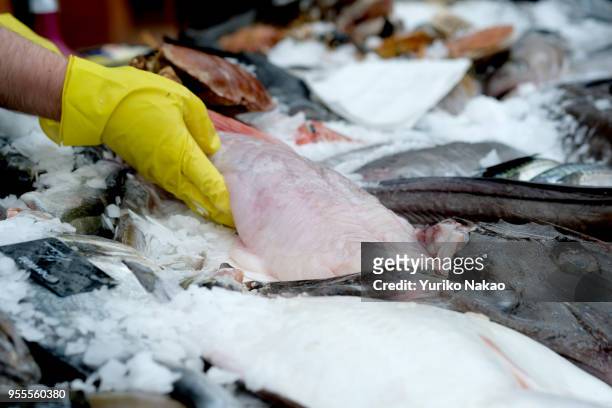 Fish monger places a salt water fish at an outdoor market during a celebration of the Koningsdag or the King's day April 27 in Katwijk, Netherlands....
