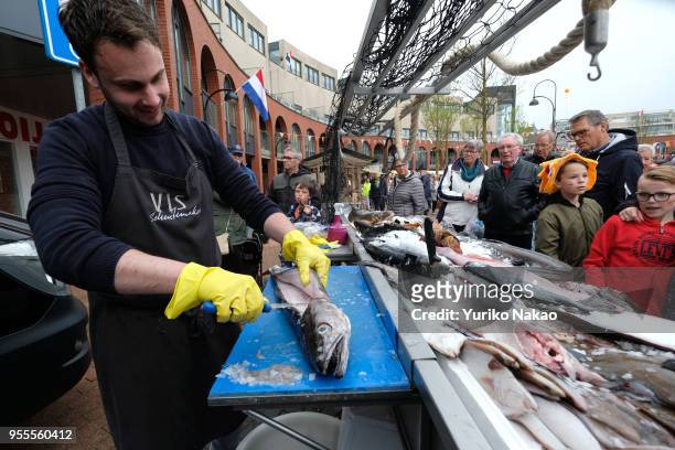 Fish monger fillets a salt water fish at an outdoor market during a celebration of the Koningsdag or the King's day April 27 in Katwijk, Netherlands....