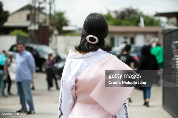 Guest with a pink hair clip wears an assymetrical white and pink dress at Mercedes-Benz Fashion Week Tbilisi FW18 on May 4, 2018 in Tbilisi, Georgia.