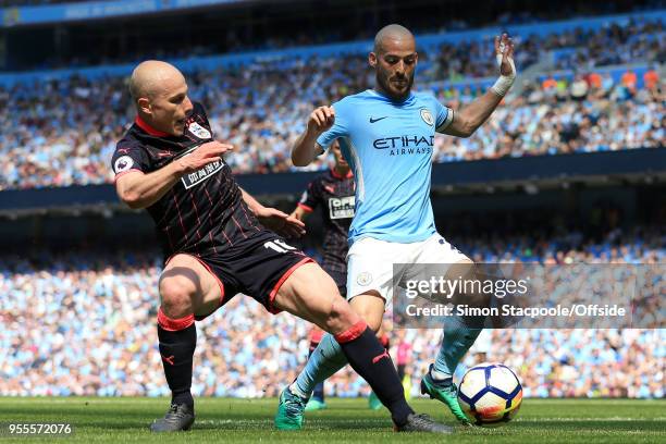 Aaron Mooy of Huddersfield battles with David Silva of Man City during the Premier League match between Manchester City and Huddersfield Town at the...