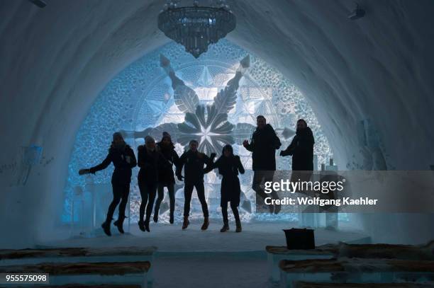 People jumping up in the Ceremony Hall of the classic Icehotel in Jukkasjarvi near Kiruna in Swedish Lapland; northern Sweden.