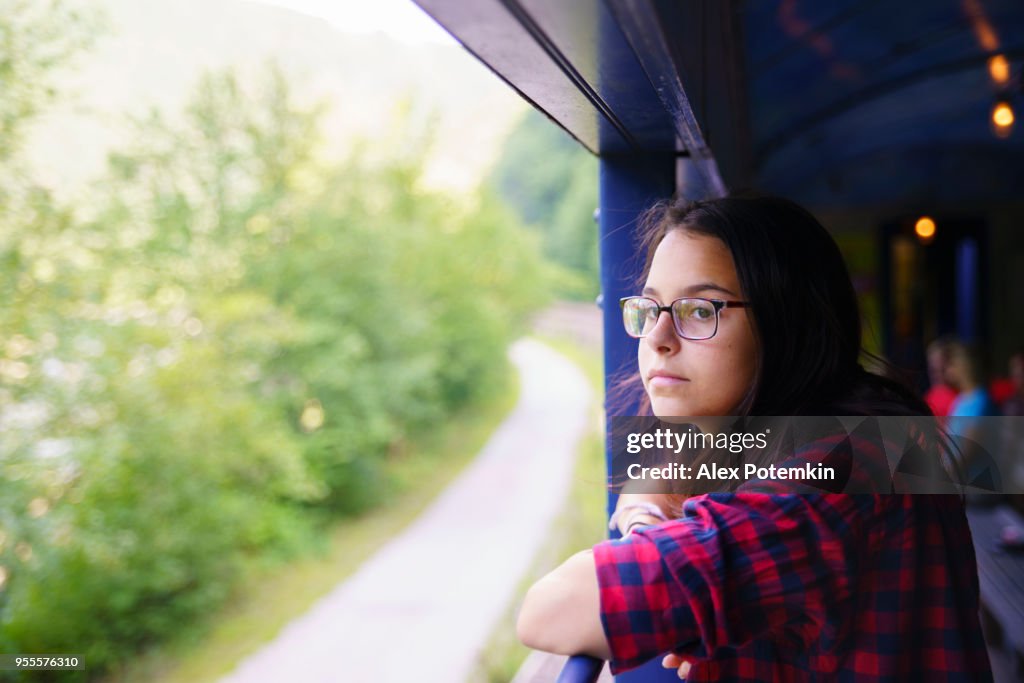 The attractive 15-years-old teenager girl enjoy the train ride through the scenic landscapes.