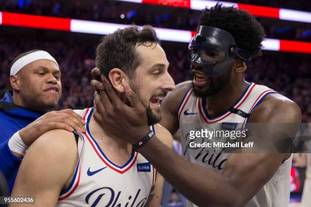Marco Belinelli of the Philadelphia 76ers reacts along with Joel Embiid after tying the game at the end of regulation against the Boston Celtics...