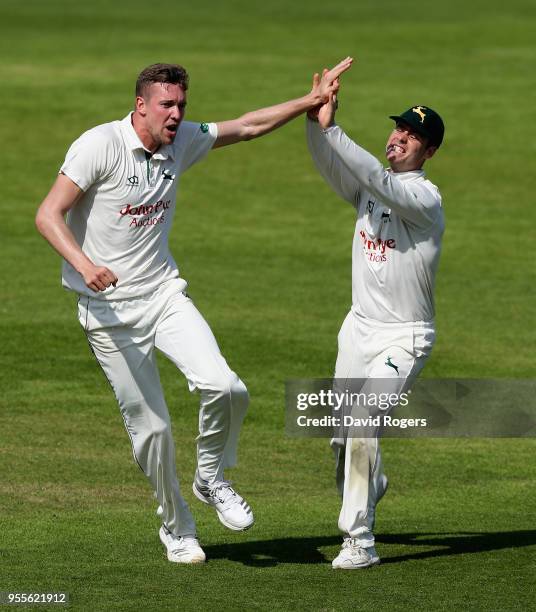 Jake Ball of Nottinghamshire celebrates with team mate Jake Libby after taking the wicket of Kyle Abbott during day four of the Specsavers County...