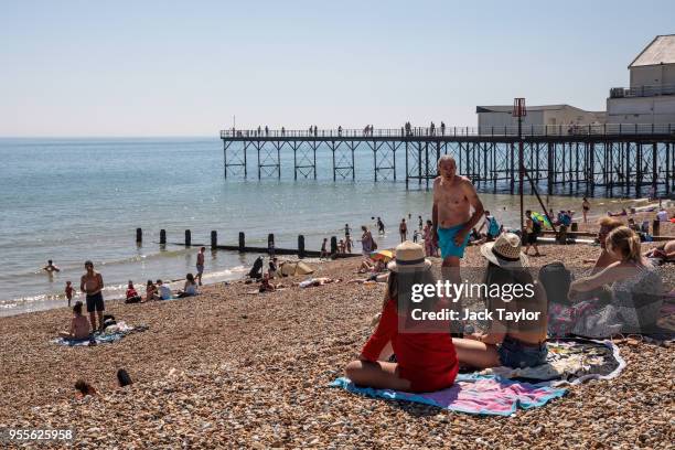 People gather on the beach by the pier during the warm weather on Bank Holiday Monday on May 7, 2018 in Bognor Regis, United Kingdom. Britons across...