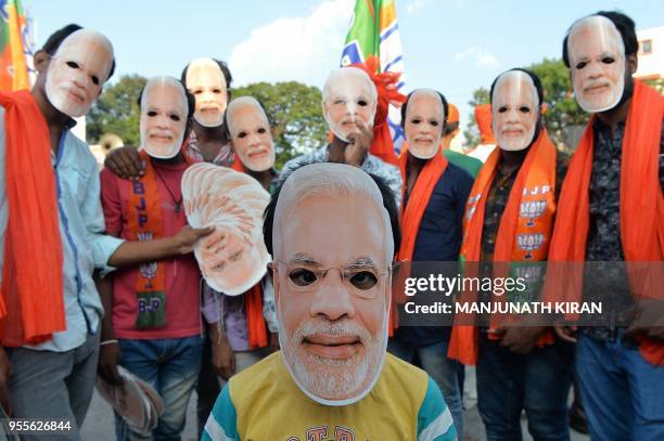 Bharatiya Janatha Party supporters wear masks of Prime Minister Narendra Modi during an election campaign of President Amit Shah for the forthcoming...