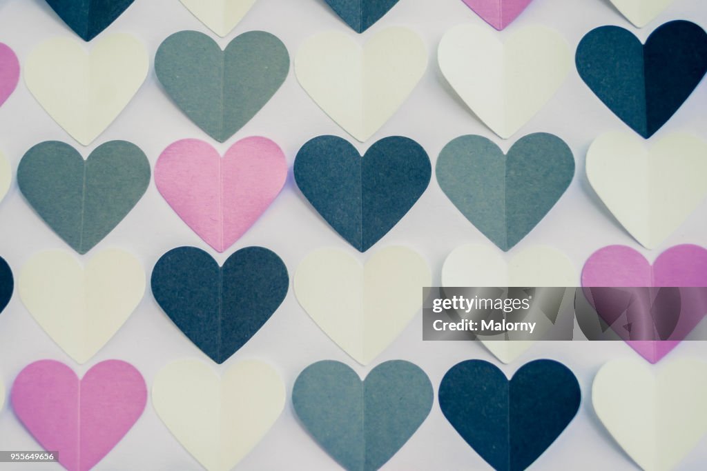 Colorful heart shaped papers on white background.