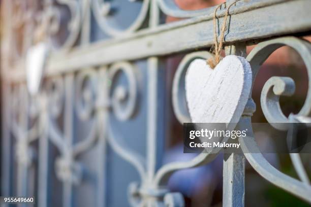 wooden heart hanging on an iron fence. - wedding guest gifts stock pictures, royalty-free photos & images