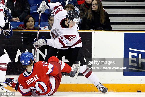 Roman Horak of Team Czech Republic is body checked by Miks Lipsbergs of Team Latvia during the 2010 IIHF World Junior Championship Tournament...