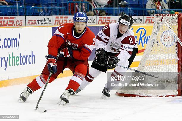 Jan Kovar of Team Czech Republic skates with the puck while being defended by Janis Smits of Team Latvia during the 2010 IIHF World Junior...