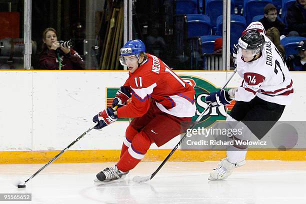 Andrej Nestrasil of Team Czech Republic skates with the puck while being defended by Rolands Gritans of Team Latvia during the 2010 IIHF World Junior...
