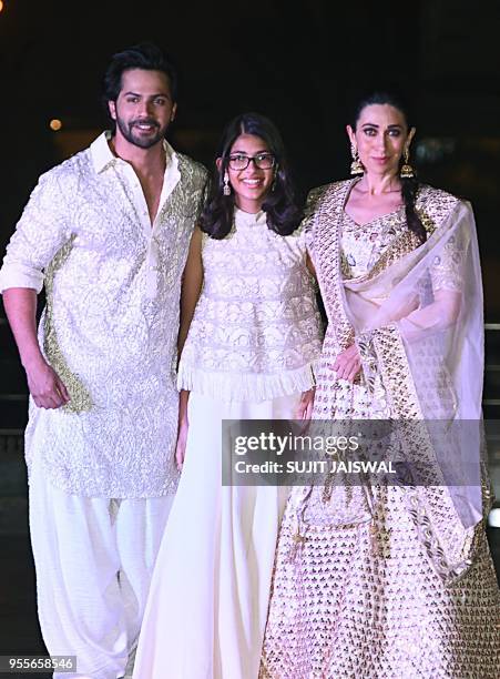Indian Bollywood actress Karishma Kapoor with her daughter and Varu Dhawan attend the actress Sonam Kapoor Sangeet ceremony in Mumbai on May 7, 2018.
