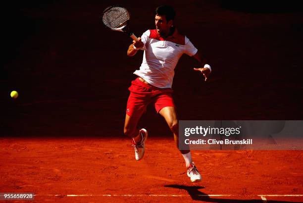 Novak Djokovic of Serbia plays a forehand against Kei Nishikori of Japan in their first round match during day three of the Mutua Madrid Open tennis...