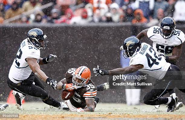 Jerome Harrison of the Cleveland Browns dives for yardage surrounded by Daryl Smith Gerald Alexander and Justin Durant of the Jacksonville Jaguars at...