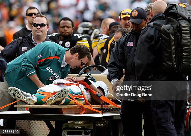 Quarterback Pat White of the Miami Dolphins is carted off the field after being knocked unconcious in the third quarter against the Pittsburgh...