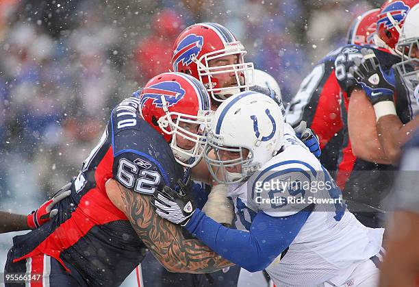 Richie Incognito and Geoff Hangartner of the Buffalo Bills block John Gill of the Indianapolis Colts at Ralph Wilson Stadium on January 3, 2010 in...