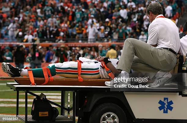 Quarterback Pat White of the Miami Dolphins is carted off the field after being knocked unconcious in the third quarter against the Pittsburgh...