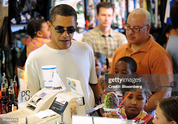 President Barack Obama orders shave ice with his daughter, Sasha, at the Island Snow shop in Kailua, Hawaii, U.S., on Friday, Jan. 1, 2010. Obama is...