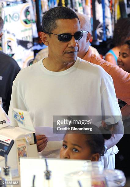 President Barack Obama orders shave ice with his daughter, Sasha, at the Island Snow shop in Kailua, Hawaii, U.S., on Friday, Jan. 1, 2010. Obama is...