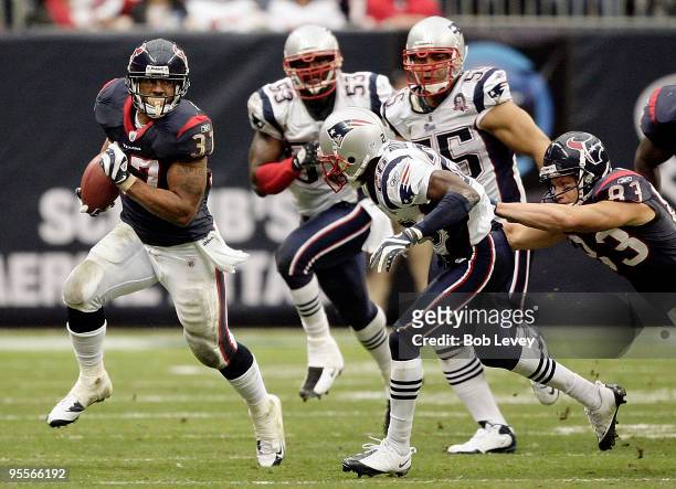 Running back Arian Foster of the Houston Texans rushes along the sideline as safety Brandon Meriweather of the New England Patriots looks to make the...