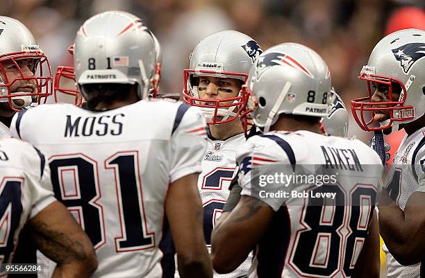 Quarterback Tom Brady of the New England Patriots goes over the play with wide receivers Randy Moss and Sam Aiken at Reliant Stadium on January 3,...