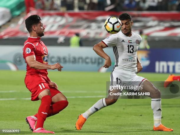 Al-Jazeera club player Mohammad Al-Musalami and Iranian Perspolis FC club player Kamal Kamyabinia, vie for the ball during their AFC Champions League...